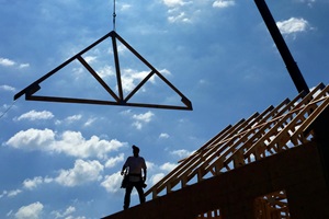 Silhouette of man on house being built